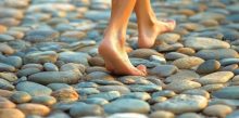 bare-feet-walking-on-a-path-made-of-smooth-stones-photo